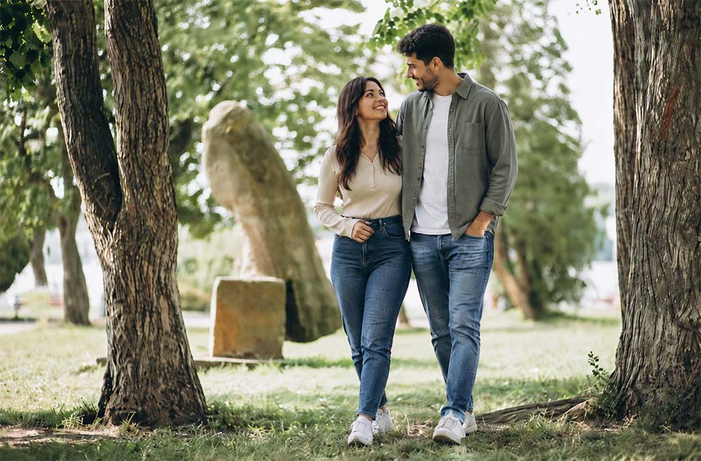 Couple walking hand in hand through a park after both choosing to meet