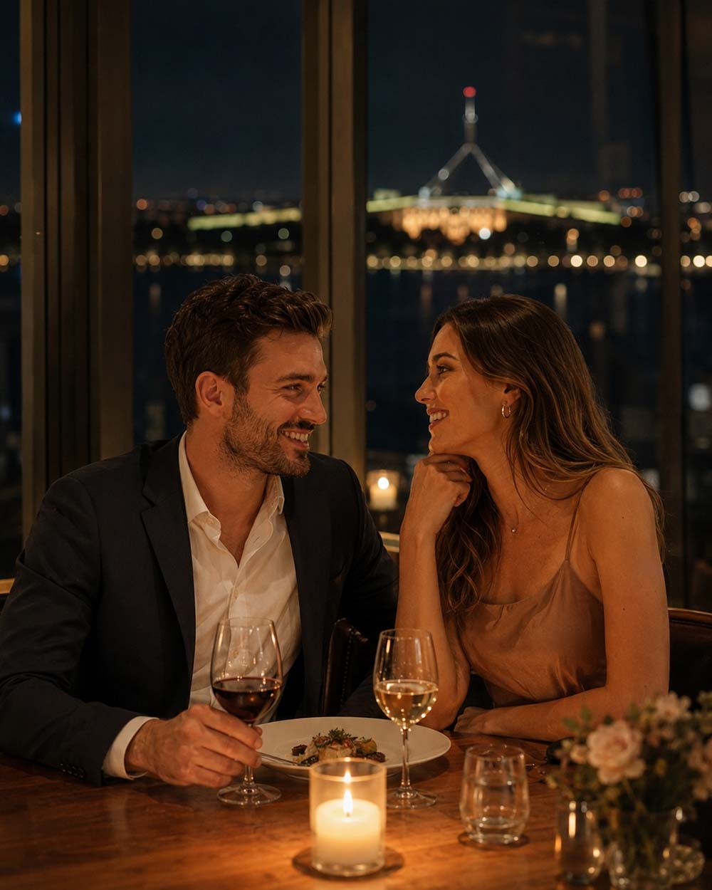 Couple on a first date at a candlelit Canberra restaurant with Parliament House lit up across the lake through the window