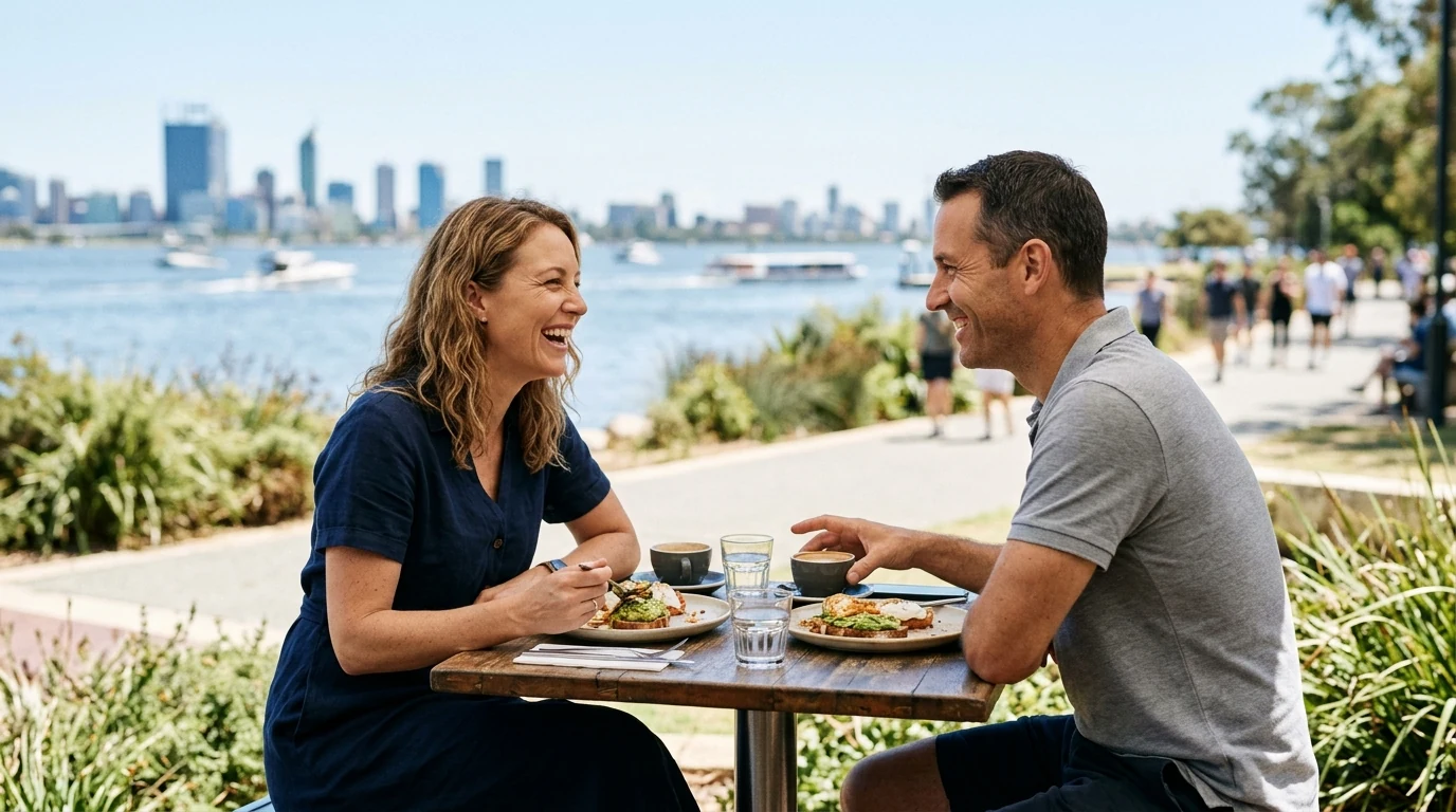 Couple laughing over brunch on a riverside path along the Swan in Perth at midday